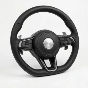 Setir sport DEMIN desain flat-bottom dibalut kulit Nappa hitam dengan jahitan perak dan insert carbon fiber pada jari-jari, difoto di atas background studio putih