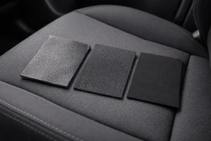 Perbandingan tekstur material seat cover mobil antara kulit premium, kain fabric, dan neoprene untuk interior kendaraan.